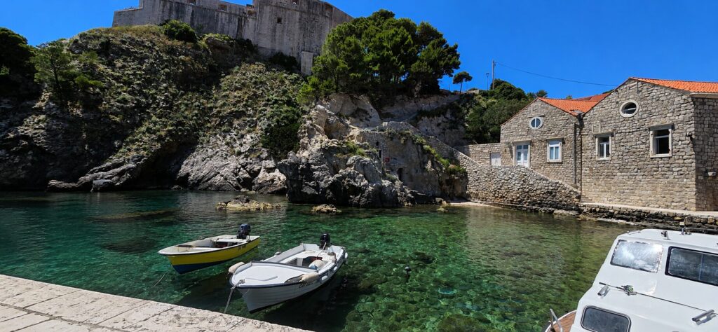 Fort Lovrijenac above Dubrovnik's Old Port with crystal-clear Adriatic water and traditional boats on a sunny day