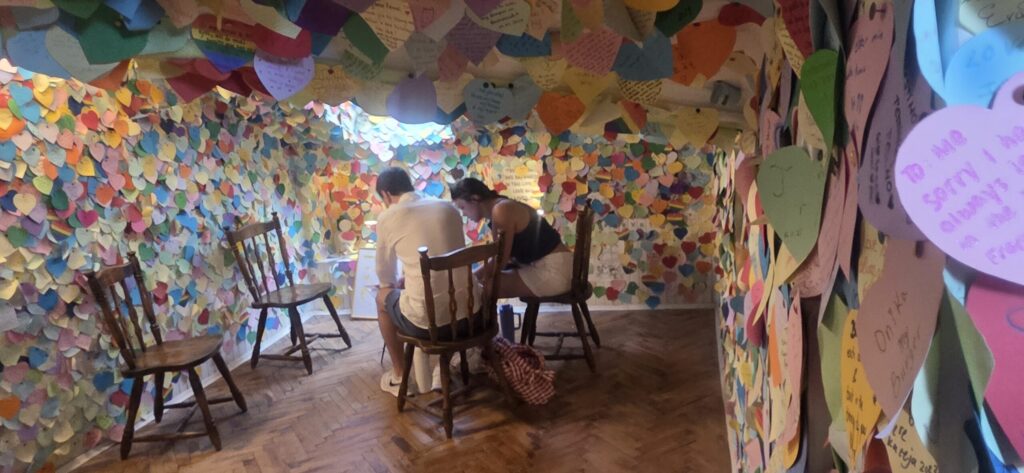 Couple writing a message among colourful love notes at the Love Stories Museum in Dubrovnik