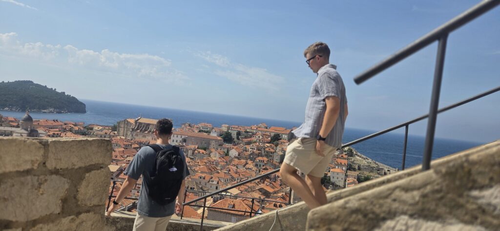 Teenagers walking on Dubrovnik City Walls above the Old Town rooftops