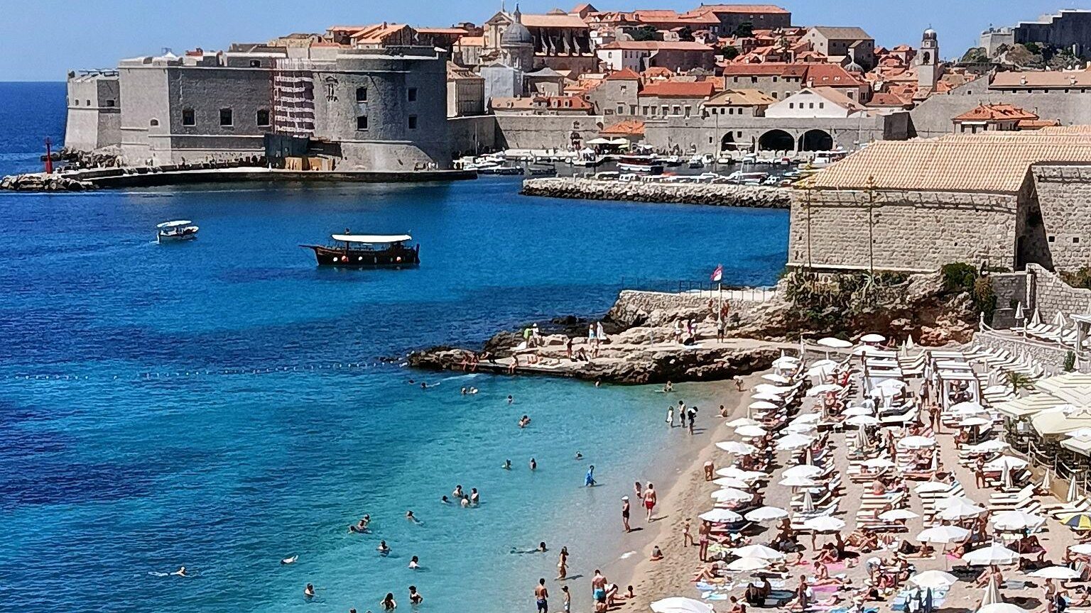 Banje Beach in Dubrovnik with view of Old Town walls and Adriatic Sea