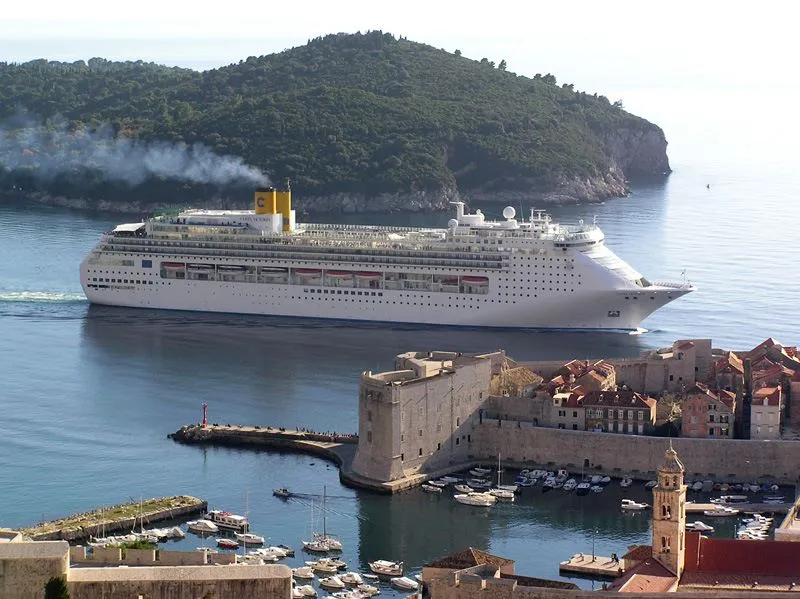 Cruise ship sailing past Dubrovnik Old Port and city walls near Lokrum Island during a shore excursion stop.