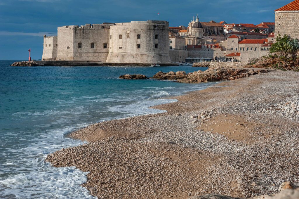 Dubrovnik Old Town city walls seen from a beach with Adriatic Sea in Croatia