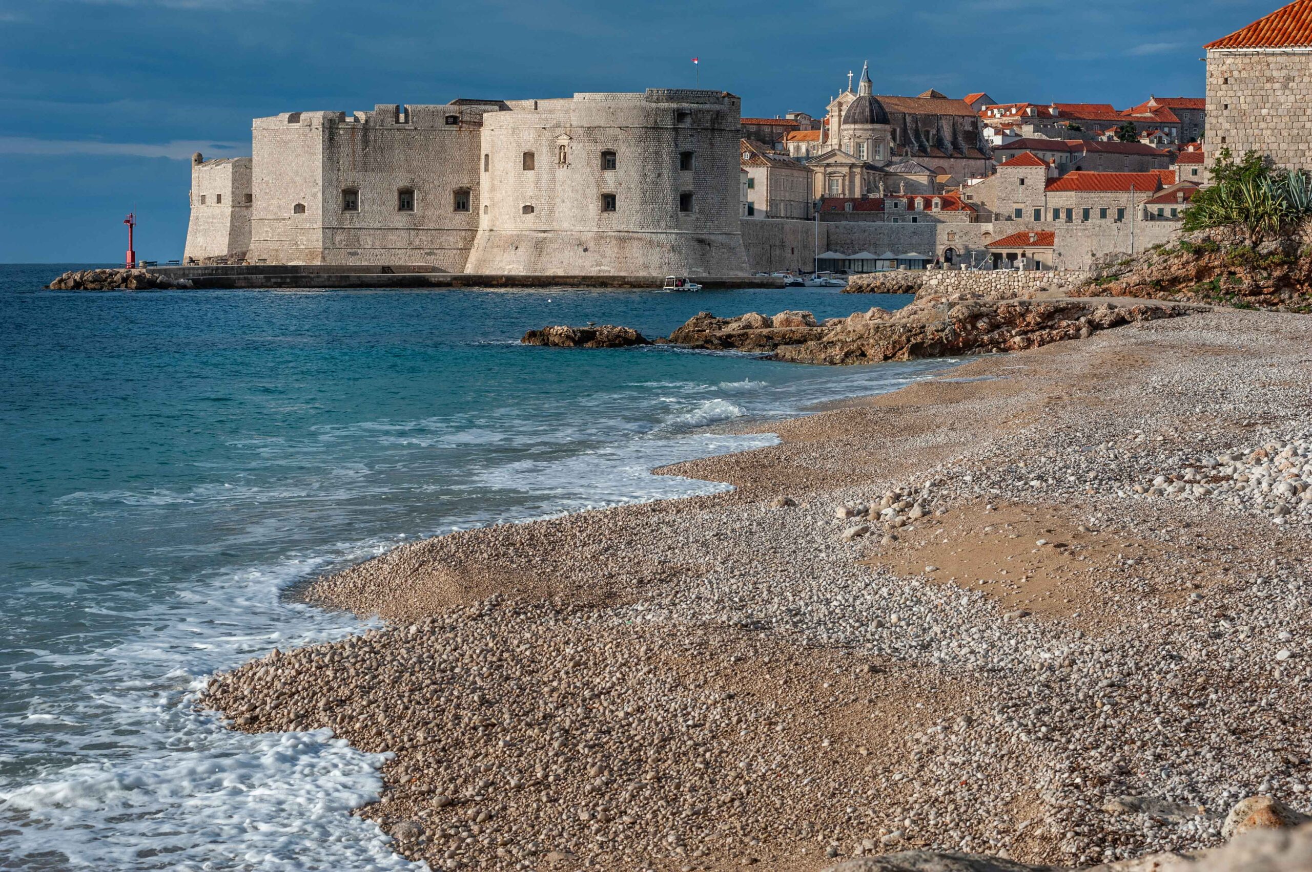 Dubrovnik Old Town city walls seen from a beach with Adriatic Sea in Croatia