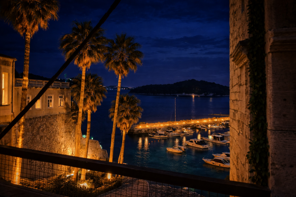 Dubrovnik Old Town harbor at night with boats and Lokrum island