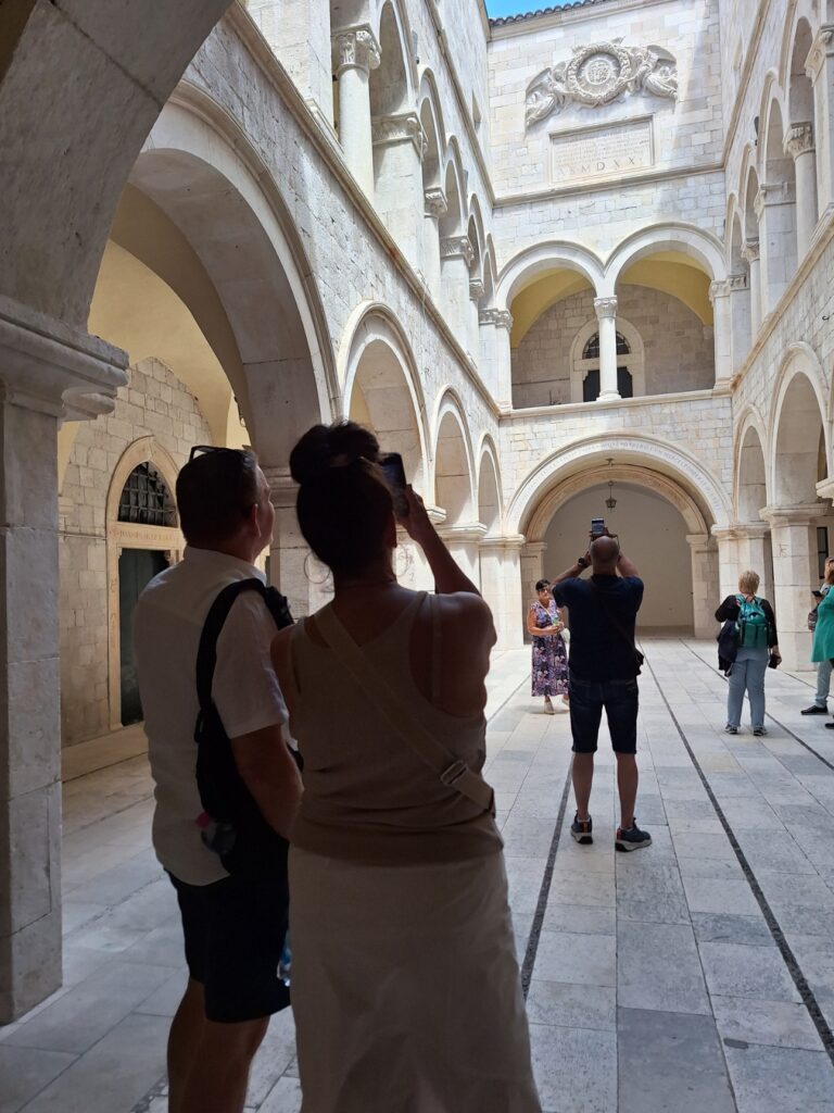 Private walking tour in Dubrovnik Old Town courtyard without crowds with visitors exploring historic architecture