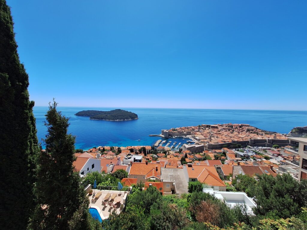 Panoramic drive above Dubrovnik with view of Old Town rooftops, Lokrum Island and Adriatic Sea