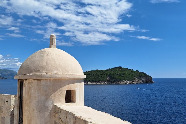 View from the Walls of Dubrovnik overlooking Lokrum Island and the Adriatic Sea under blue Mediterranean skies.