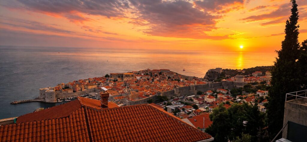 Dubrovnik Old Town at sunset with city walls, red rooftops and the Adriatic Sea, showing the best evening time to visit Dubrovnik Old Town