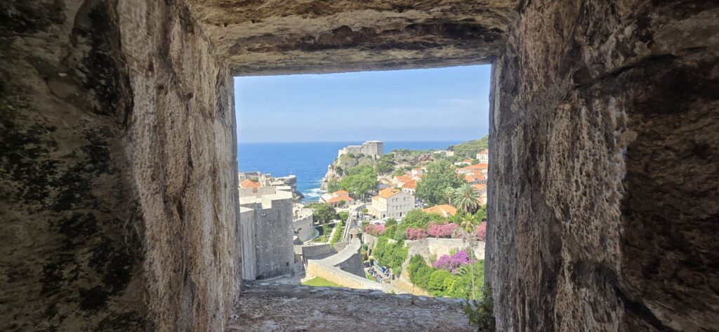 Hidden view of Dubrovnik from the city walls, showing Fort Lovrijenac, the Adriatic Sea, and historic stone architecture