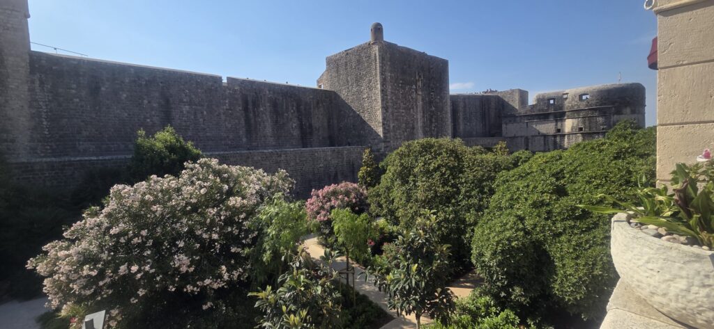 Massive stone fortifications of Dubrovnik City Walls overlooking a garden near Dubrovnik Old Town