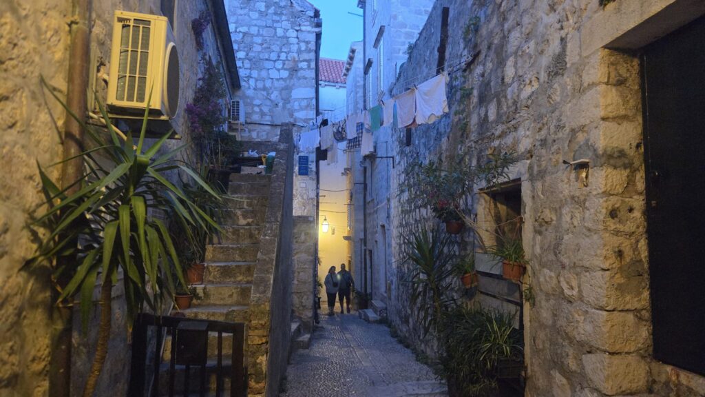 Laundry hanging between stone houses in a quiet Dubrovnik Old Town alley, showing everyday local life in Croatia.