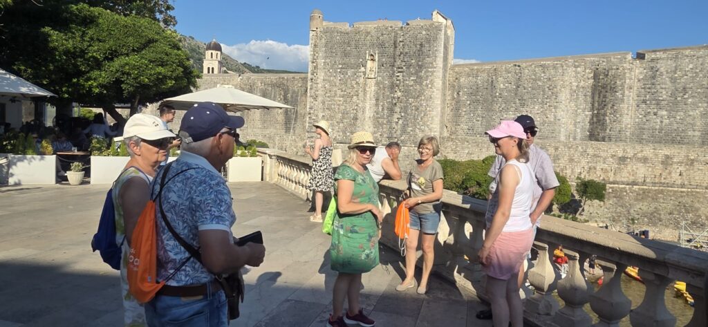 Senior travelers enjoying a relaxed early morning walking tour in Dubrovnik near the city walls with a local guide