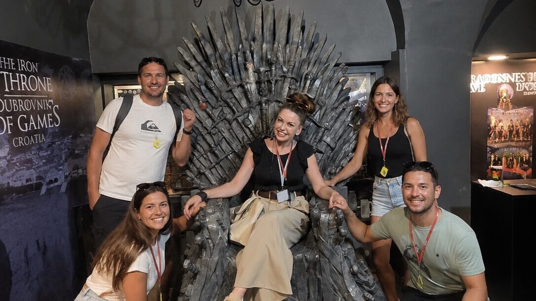 Visitors posing on the Iron Throne during a Game of Thrones tour experience in Dubrovnik
