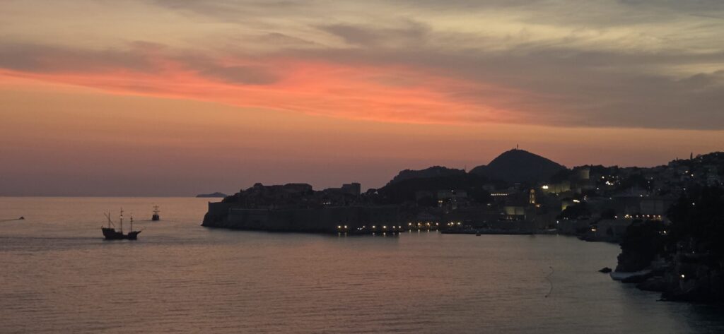Sunset over Dubrovnik Old Town with the Adriatic Sea and a sailing ship