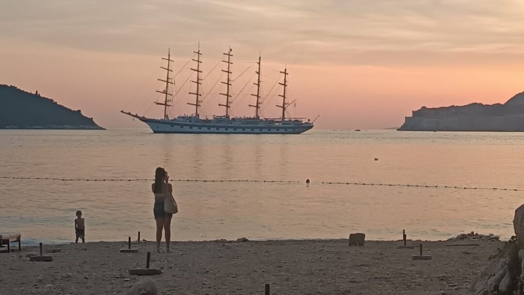 Sunset from Sveti Jakov Beach with a sailing ship, Lokrum and Dubrovnik Old Town