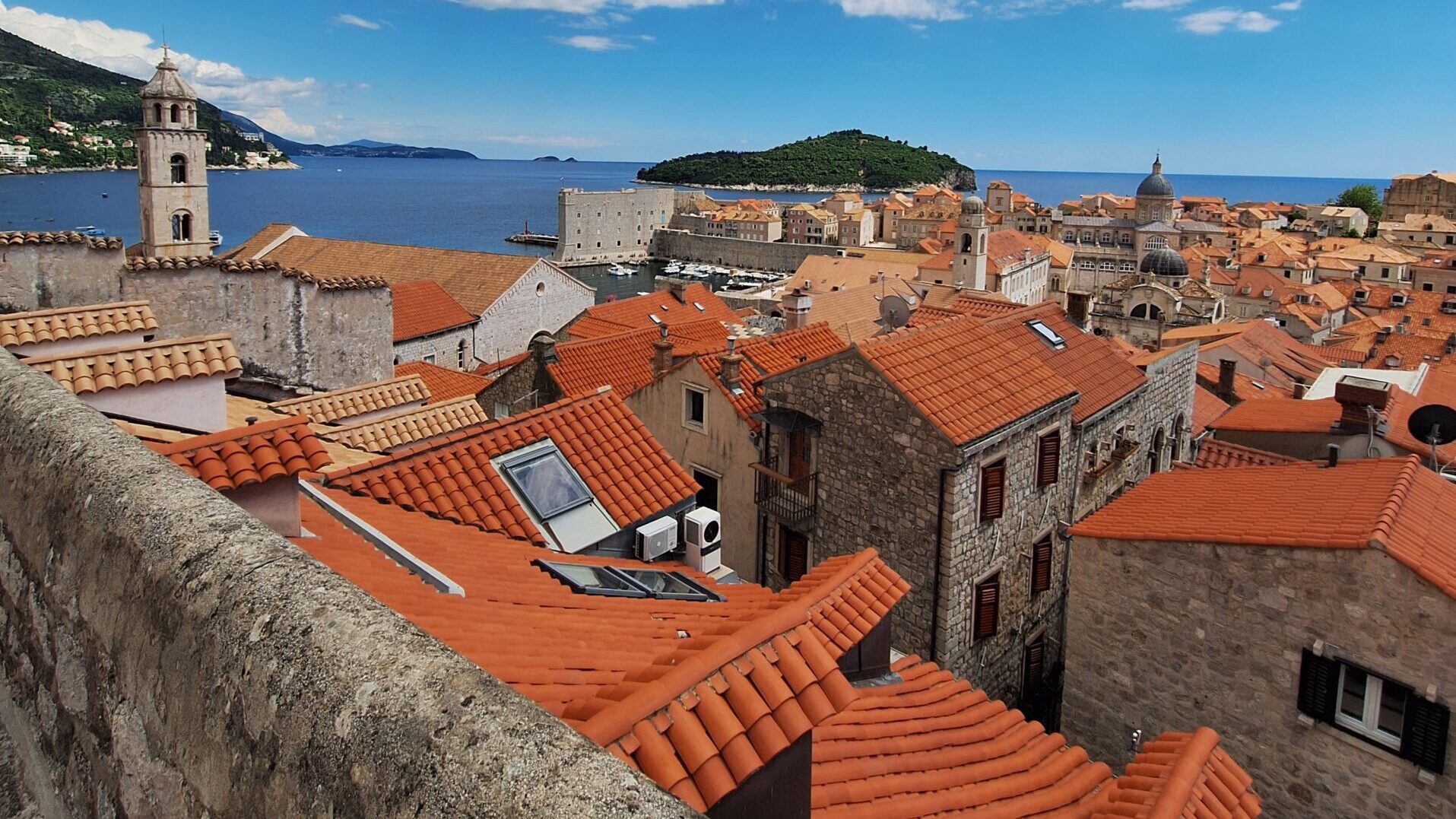 View from Dubrovnik City Walls over Old Town rooftops, the Old Port and Lokrum Island
