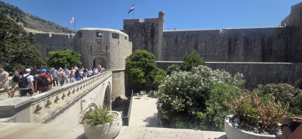 Pile Gate entrance to Dubrovnik Old Town, with the stone bridge, defensive walls and visitors entering the historic centre.