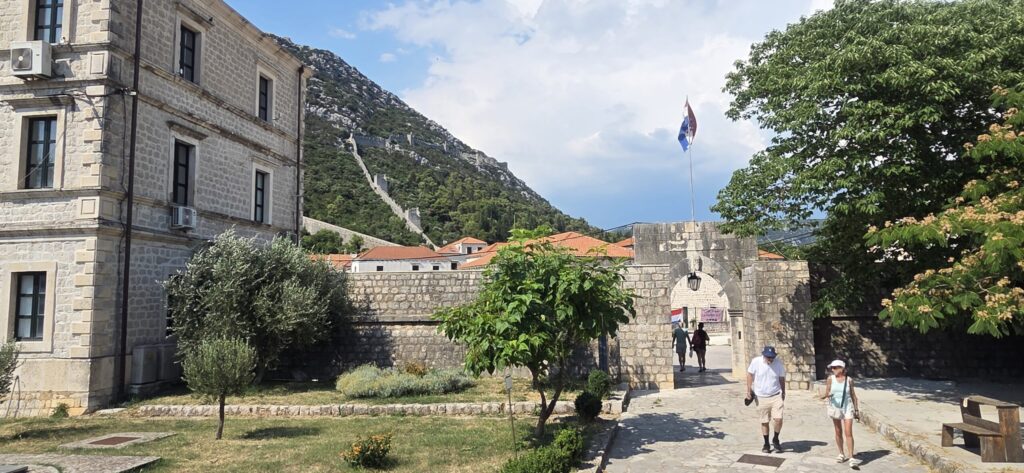 Historic entrance to Ston Old Town with the defensive walls climbing the hillside above